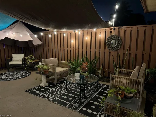 Patio at night with a patio area and a fenced backyard