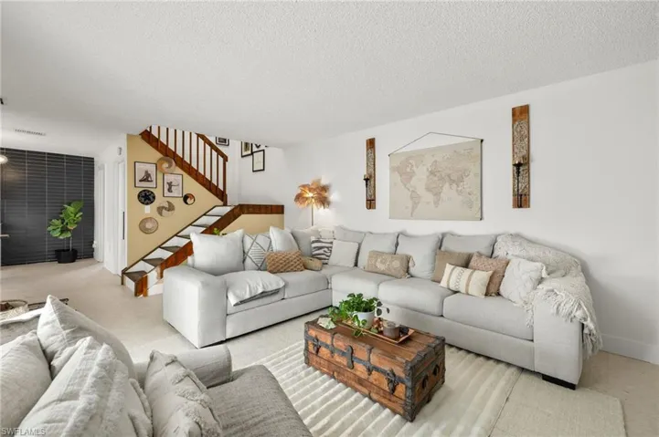 Living area with light carpet and a textured ceiling