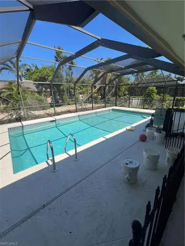 View of pool featuring a patio and glass enclosure