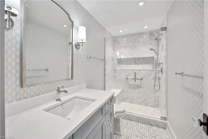 Primary suite bath with freestanding soaking tub and waterfall tile design