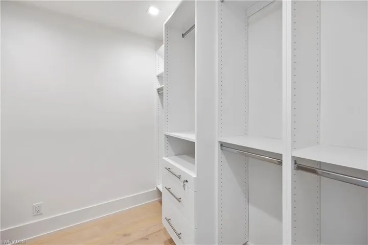 Primary suite bedroom walk-in closet featuring built-in cabinets (1 of 2 primary walk-in closets)