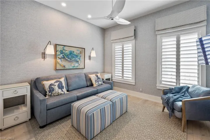 Guest bedroom three/den featuring engineered wood flooring, grasscloth wallpaper, recessed lighting, and plantation shutters
