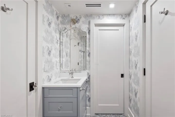 Hall bath with wallpaper and vanity