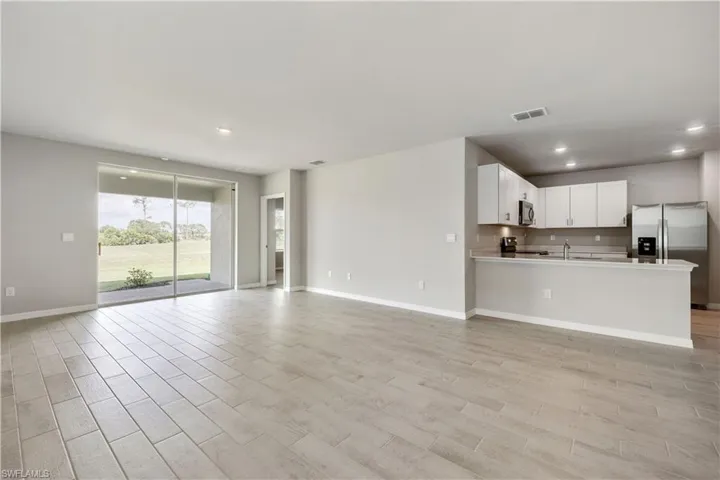 Unfurnished living room featuring sink and light hardwood / wood-style floors
