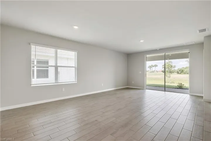 Spare room featuring plenty of natural light and light hardwood / wood-style floors