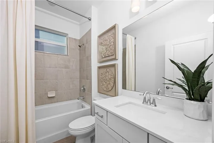 Bathroom with shower / tub combo with curtain and vanity