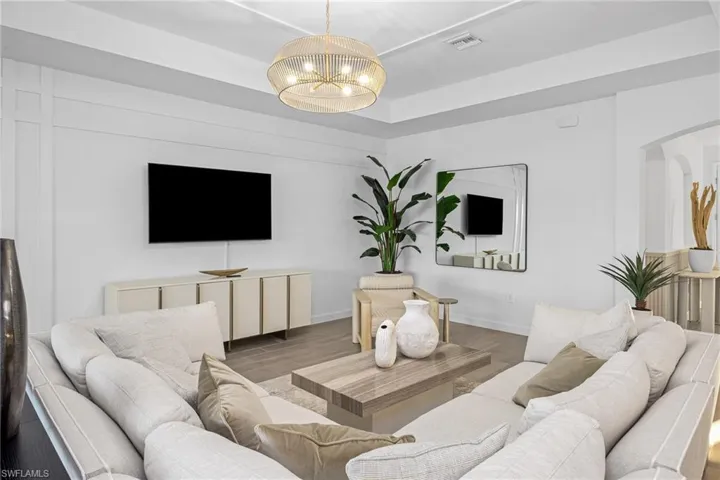 Living area with wood finished floors and a raised ceiling