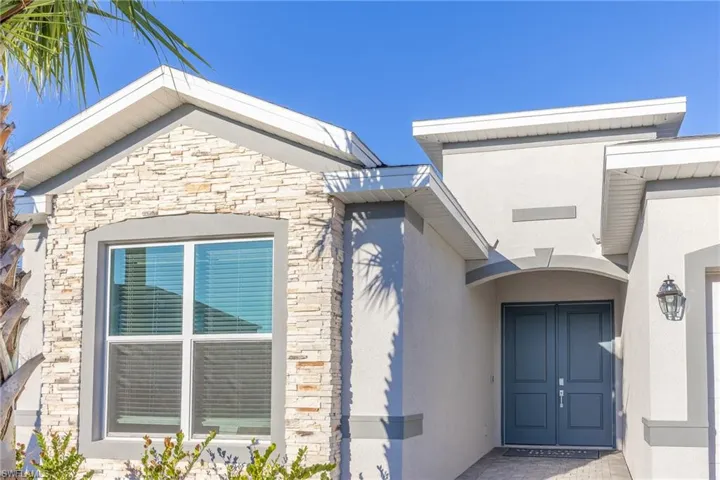 View of exterior entry with stone siding and stucco siding