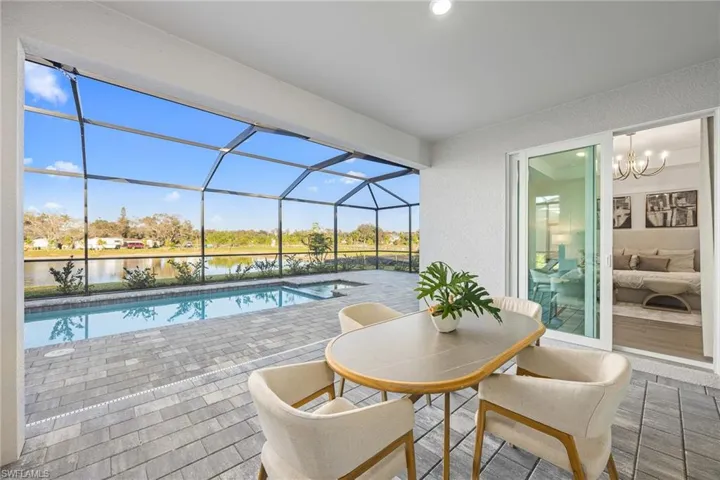 Outdoor pool with a sunroom, a patio area, a lanai, and a water view