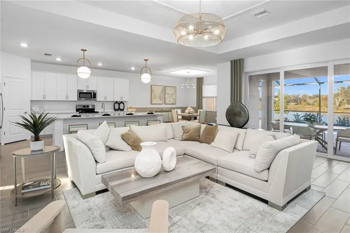 Living area featuring a water view, a chandelier, light wood-style floors, and recessed lighting