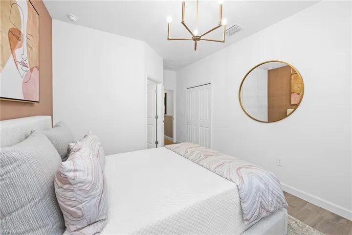 Bedroom with wood finished floors and a chandelier