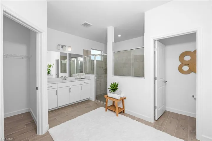 Full bath with wood finish floors, a shower stall, and vanity