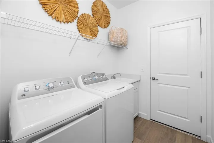 Washroom with dark wood finished floors and washer and dryer
