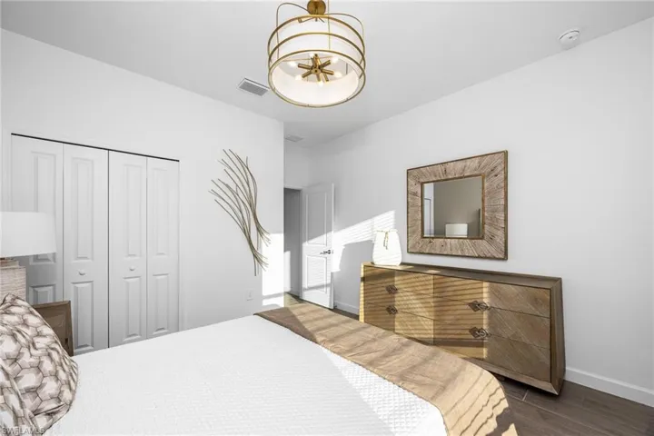 Bedroom featuring dark wood finished floors, a closet, and a chandelier