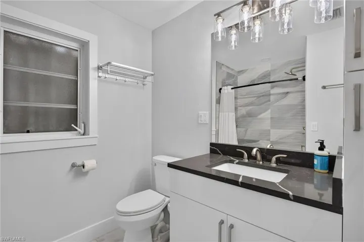 Guest bath with quartz counters, new vanity, lighting, plumbing fixtures.