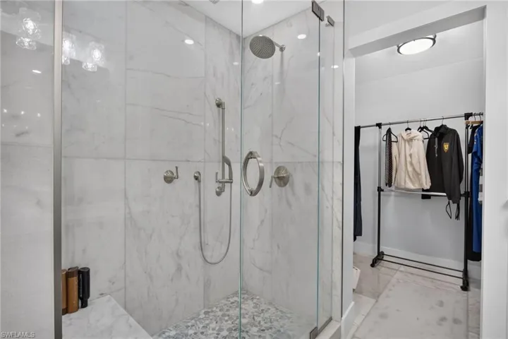 Shower with Custom tiled shower, glass shower door, and multiple heads.