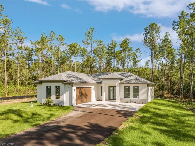View of front of house with a garage and a front lawn