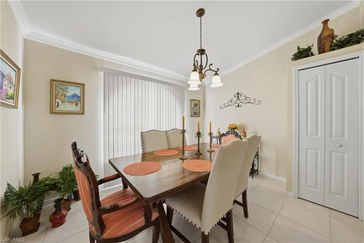 Dining room with crown molding, light tile patterned floors, and suspended lighting