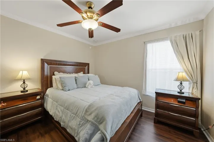 Bedroom featuring crown molding, ceiling fan, and dark wood-style floors