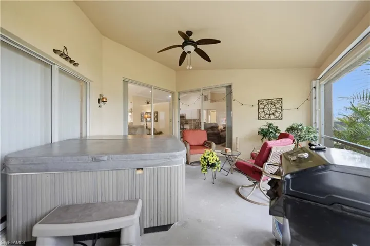 Sunroom / solarium with a jacuzzi, ceiling fan, and lofted ceiling