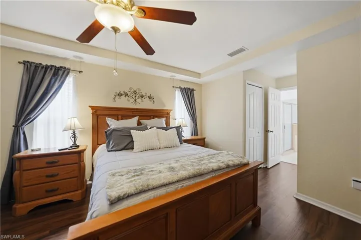 Bedroom featuring dark wood-style floors, a ceiling fan, and a closet