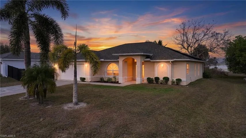 View of front of house with an attached garage, stucco siding, a front yard, and concrete driveway