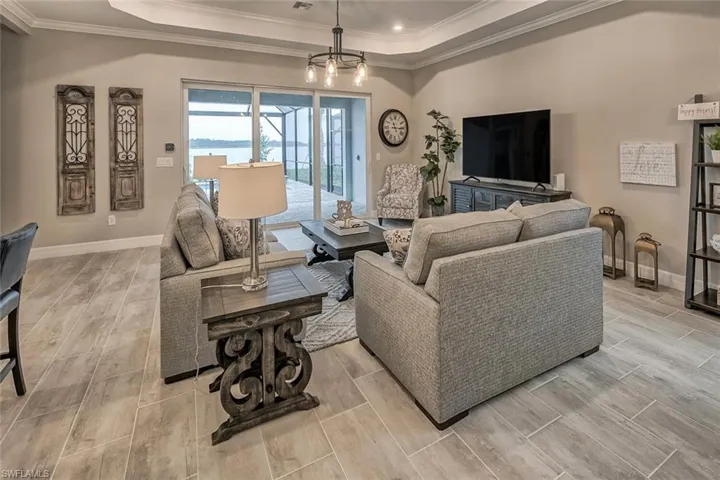 Living area featuring wood finish floors, a raised ceiling, and baseboards
