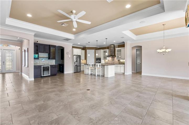 Wonderful wet bar area with a wine cooler and cabinetry. Tray ceilings.