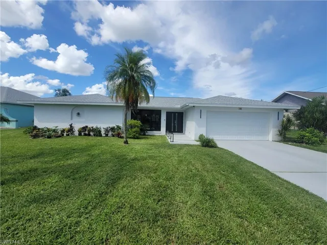 Single story home featuring driveway, an attached garage, stucco siding, and a front yard