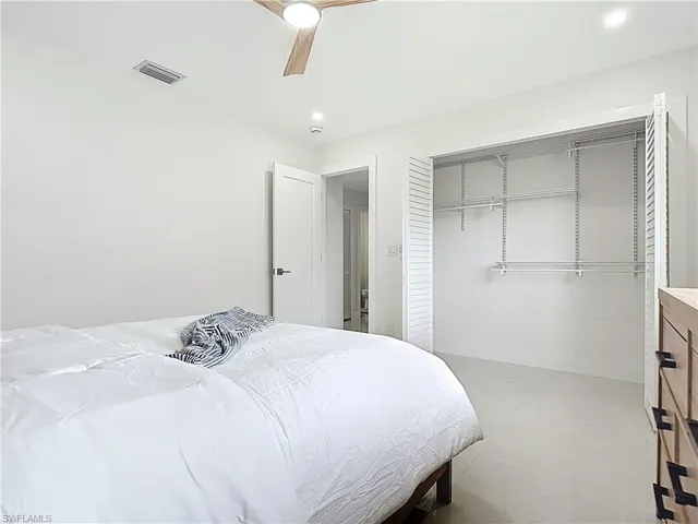 Bedroom featuring a closet, a ceiling fan, baseboards, and concrete floors