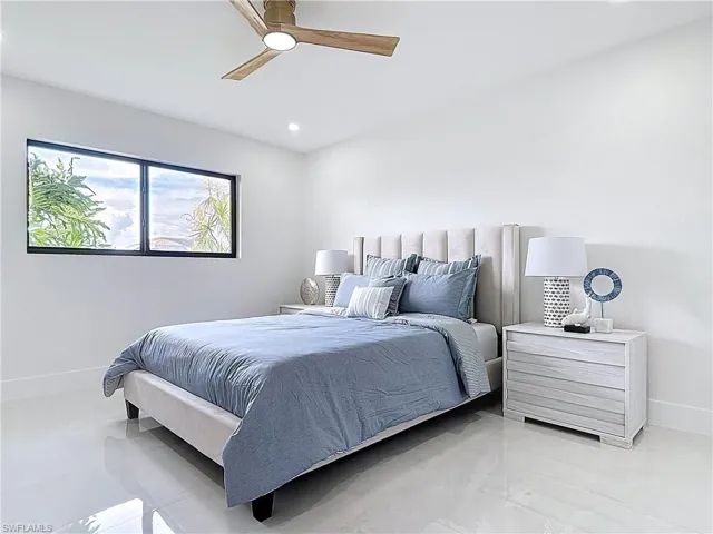 Bedroom featuring baseboards, a ceiling fan, light marble finish floors, and recessed lighting