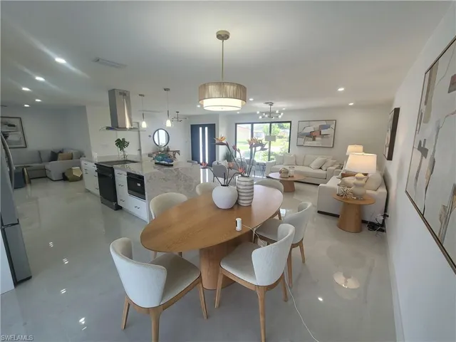Dining room with recessed lighting, a chandelier, and light tile patterned floors