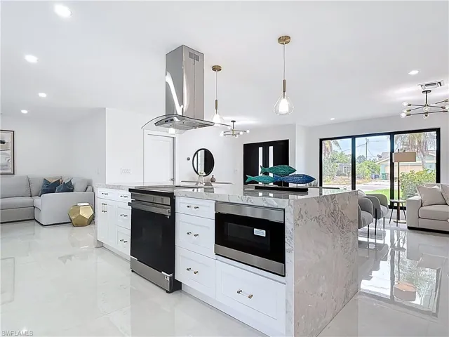 Kitchen featuring open floor plan, stainless steel range with electric cooktop, ventilation hood, a chandelier, and recessed lighting