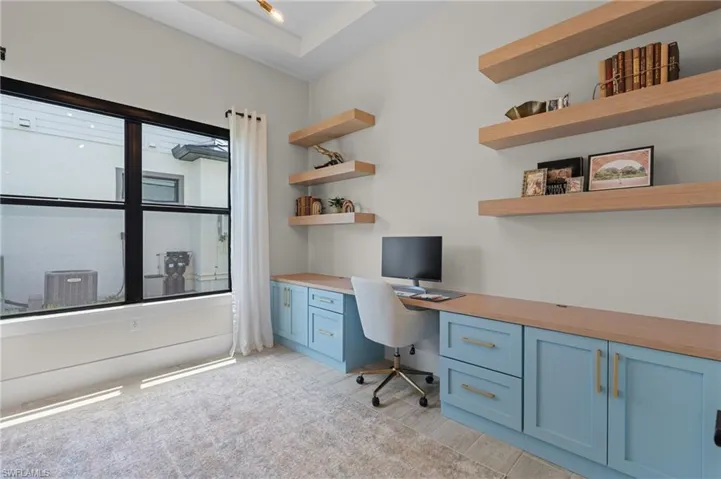 Office area with built in study area and light wood-type flooring
