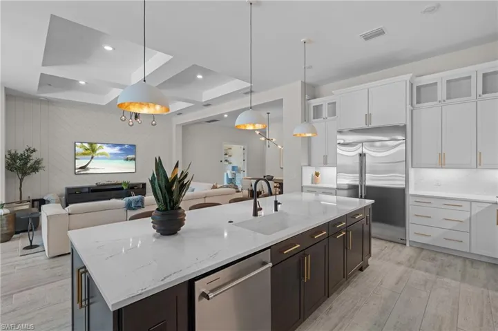Kitchen featuring a sink, light wood-style floors, white cabinetry, appliances with stainless steel finishes, and open floor plan