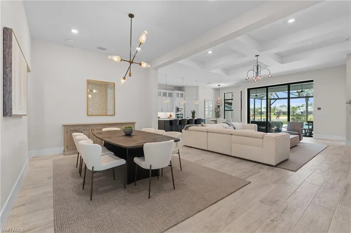 Dining room featuring coffered ceiling, a chandelier, beamed ceiling, light wood finished floors, and baseboards