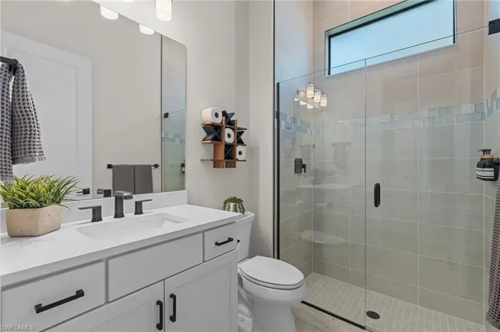 Bathroom with a stall shower, toilet, and vanity