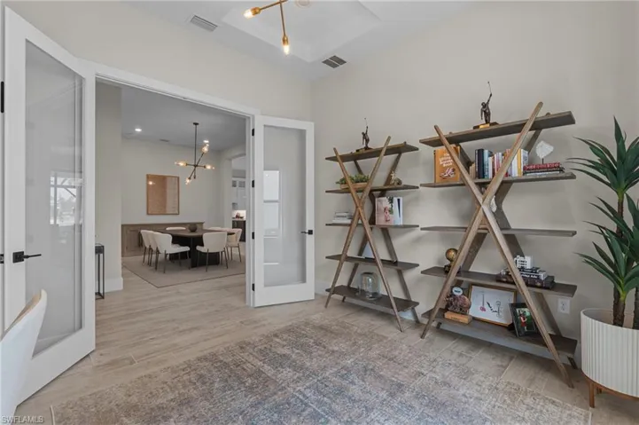 Miscellaneous room with wood finished floors, visible vents, french doors, and a chandelier