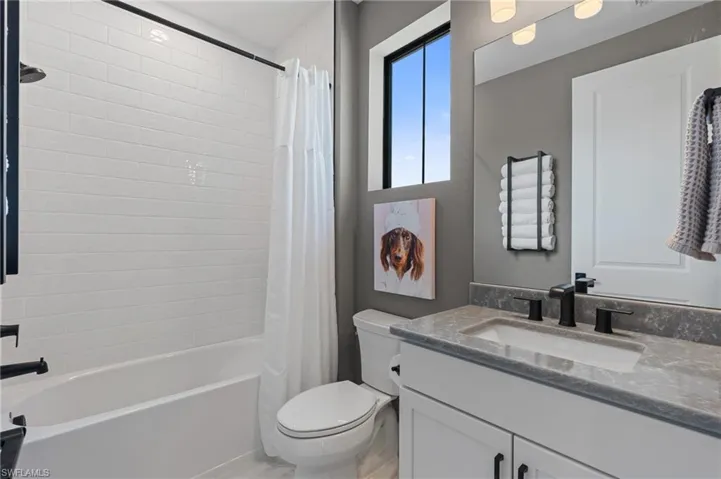 Full bath with toilet, shower / bath combo, and vanity
