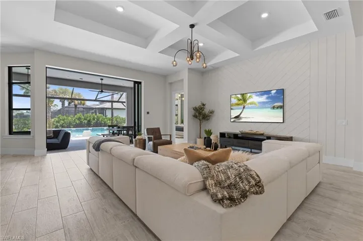 Living room with recessed lighting, coffered ceiling, light wood-style floors, baseboards, and visible vents