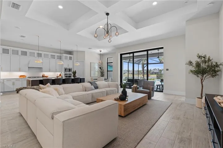 Living room with light wood-style flooring, visible vents, recessed lighting, and coffered ceiling