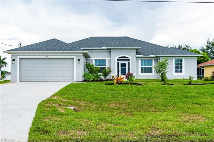 Ranch-style house featuring a garage and a front lawn