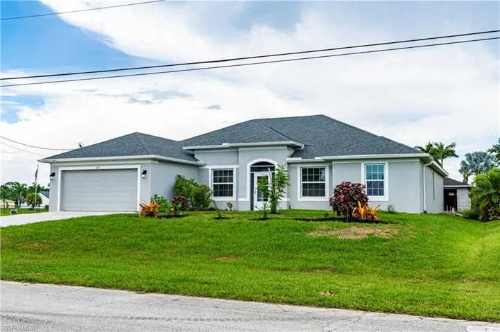 View of front of house with a garage and a front lawn