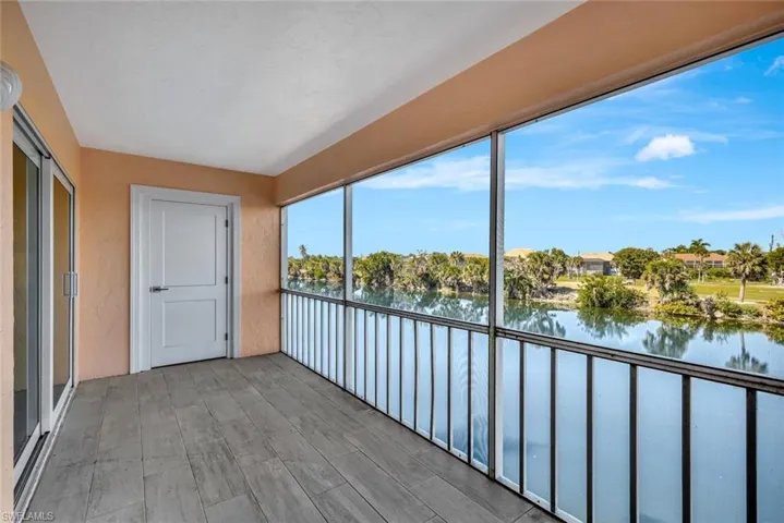 Unfurnished sunroom featuring a balcony and a water view