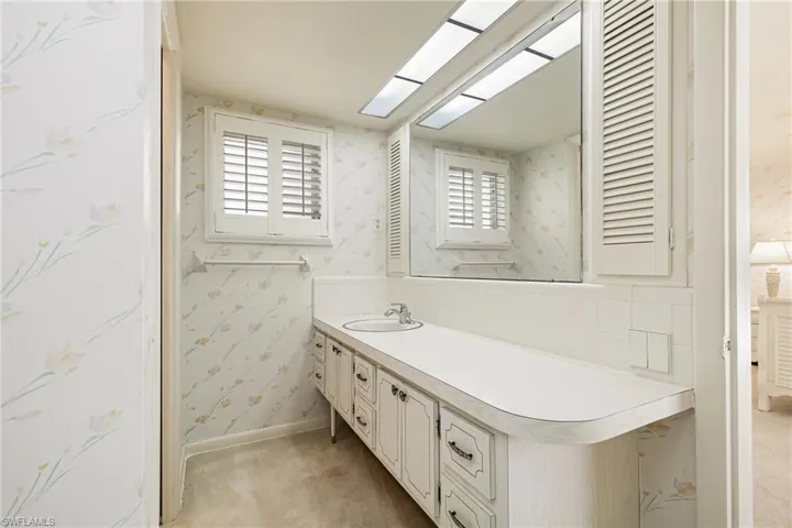 Bathroom featuring wallpapered walls, vanity, healthy amount of natural light, and a skylight