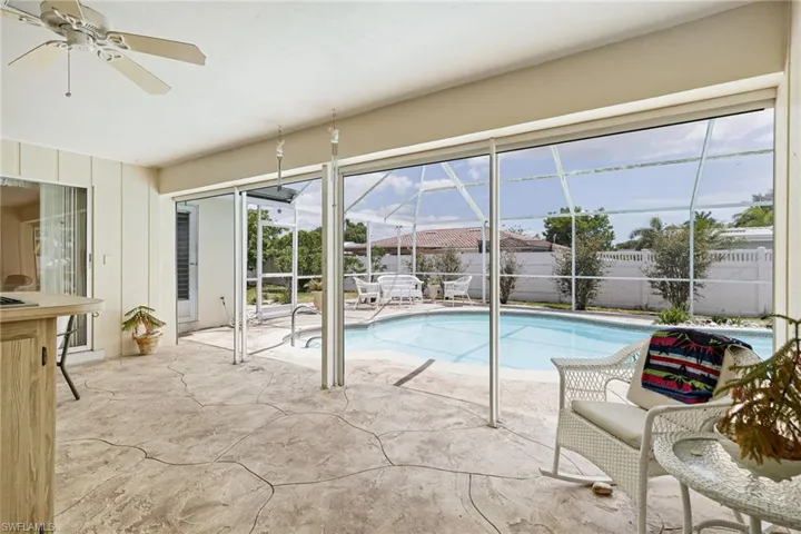 View of pool with fence, a patio area, a lanai, and a ceiling fan
