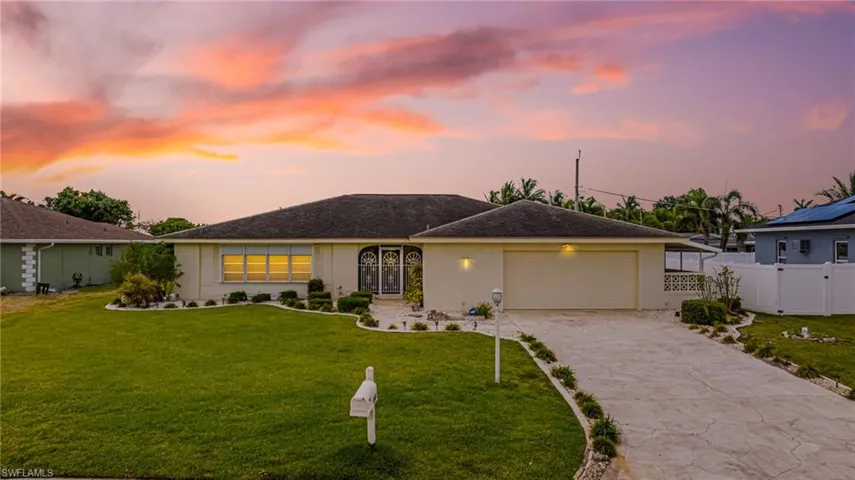 View of front of home featuring stucco siding, a garage, and driveway