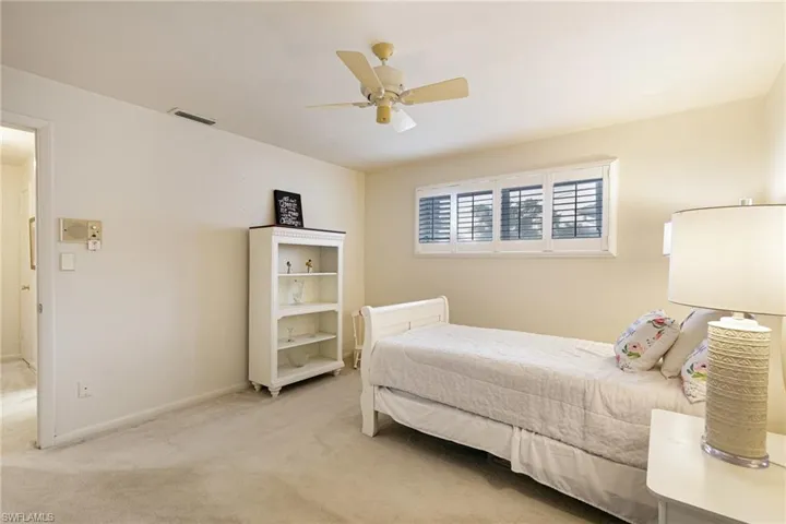 Carpeted bedroom featuring a ceiling fan and baseboards