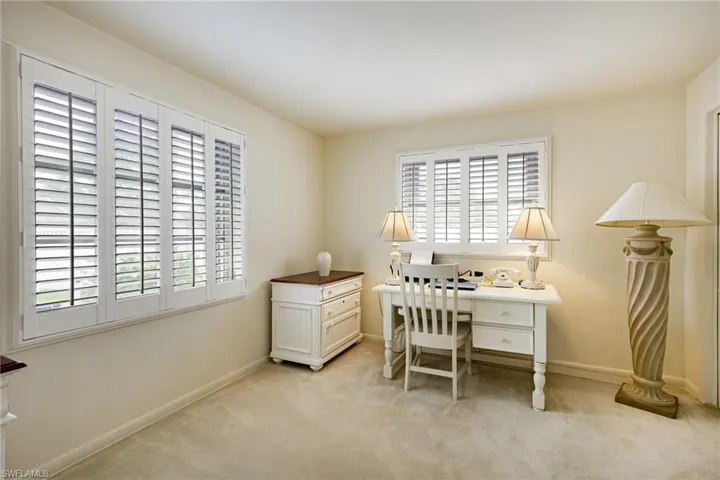 Office space featuring healthy amount of natural light, light carpet, and baseboards
