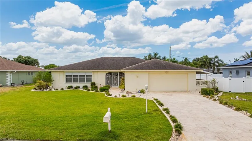Single story home with stucco siding, an attached garage, and driveway